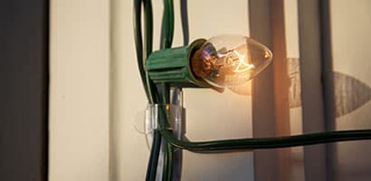Closeup of a single light on a string being secured using a Command™ light clip.