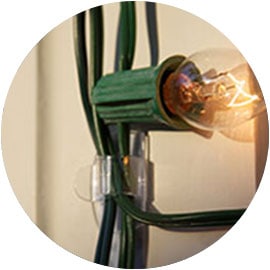 Closeup of a single light on a string being secured using a Command™ light clip.