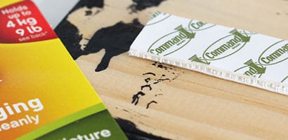 Command™ Picture Hanging Strip applied to the back of a board with a city name.