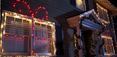 Front of a house exterior decorated for Christmas with lights strung using Command™ light clips.